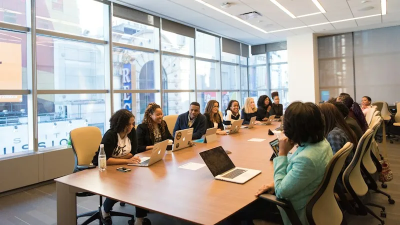 Equipo de trabajo reunido alrededor de una mesa de juntas